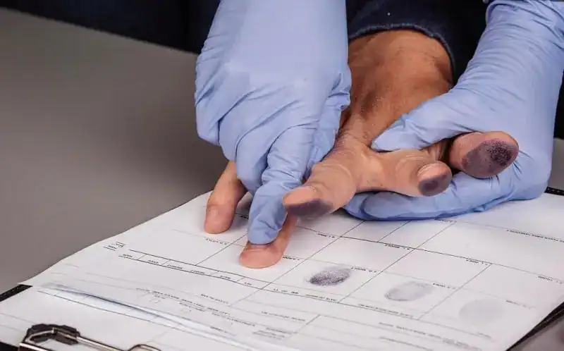 New Jersey technician collecting ink and roll fingerprints on FD-258 card.
